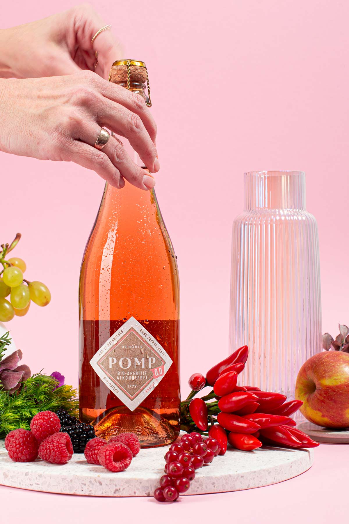 frau öffnet eine flasche alkoholfreien pomp rose 0,0