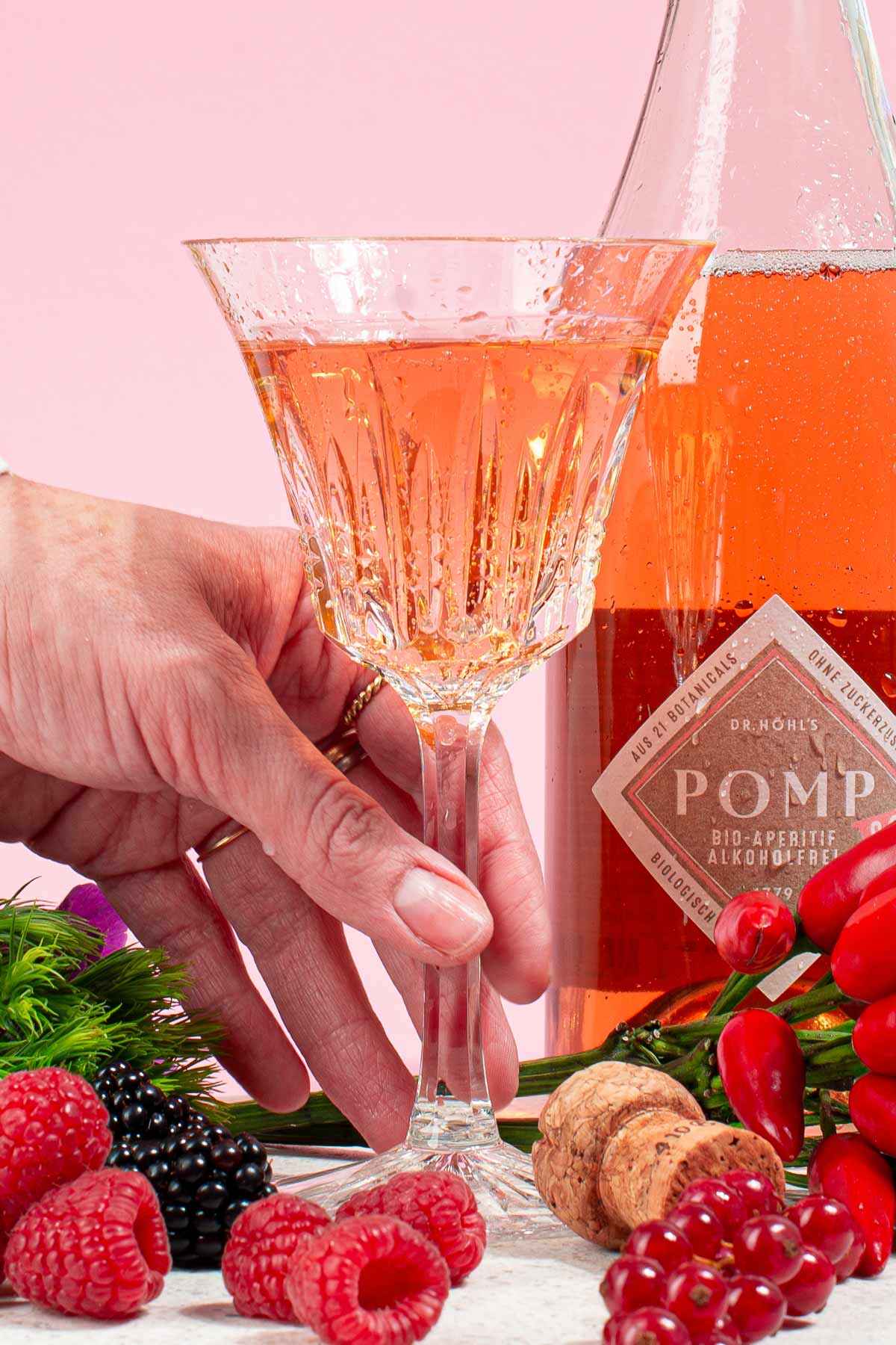 hand greift zu einem kristallglas mit alkoholfreiem sekt
