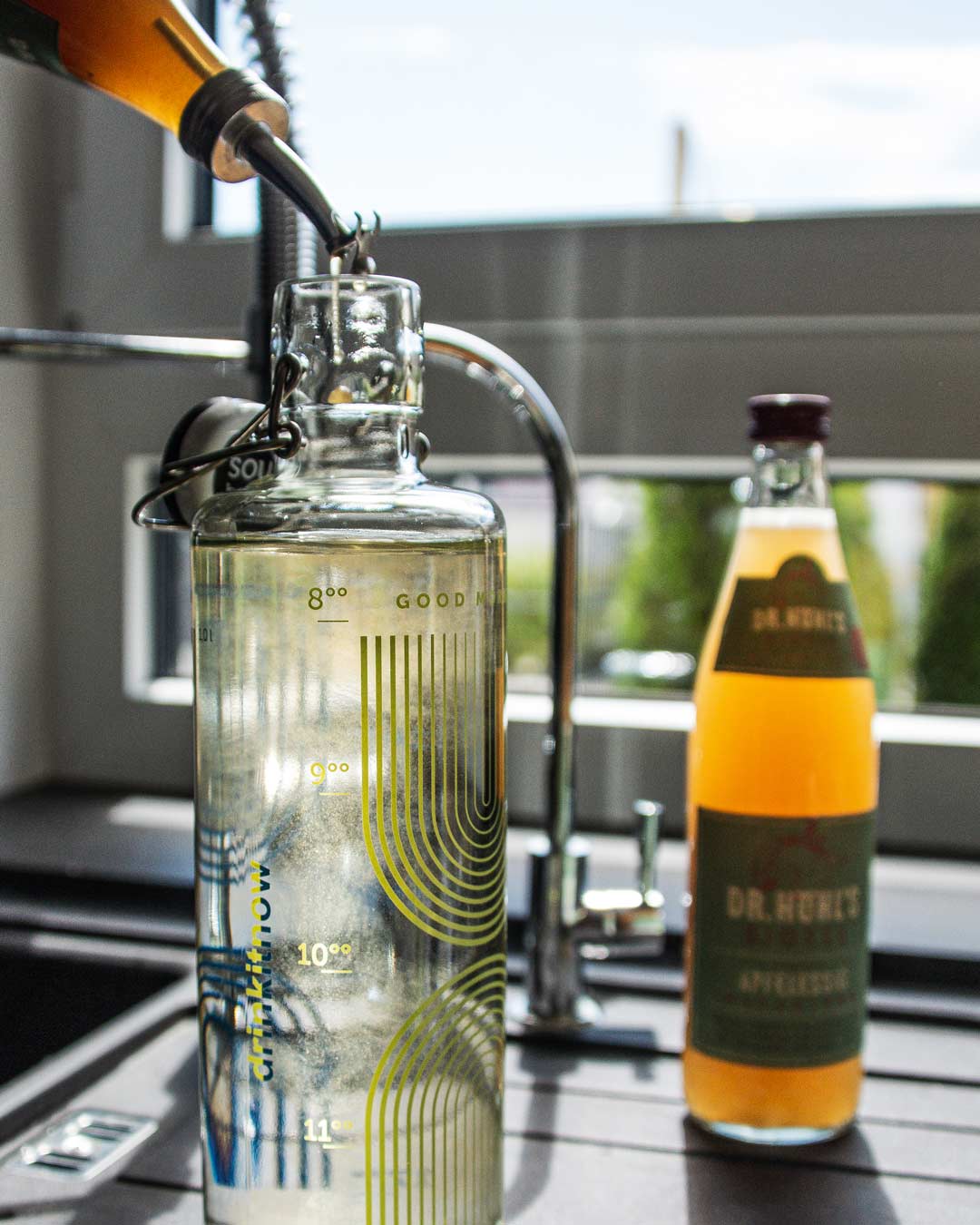 glasflasche mit wasser wird mit apfelessig aufgefüllt