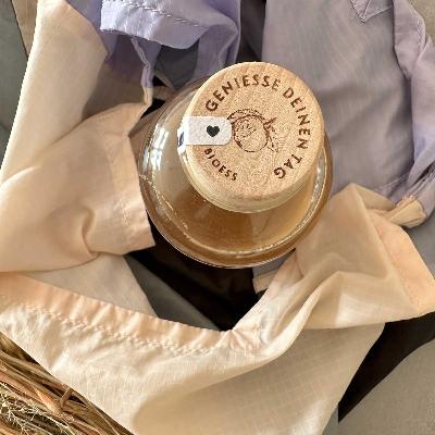 holzdeckel bioess rezeptur 1779 apfelessig flasche mit aufschrift "geniesse deinen tag" in einer einkaufstasche