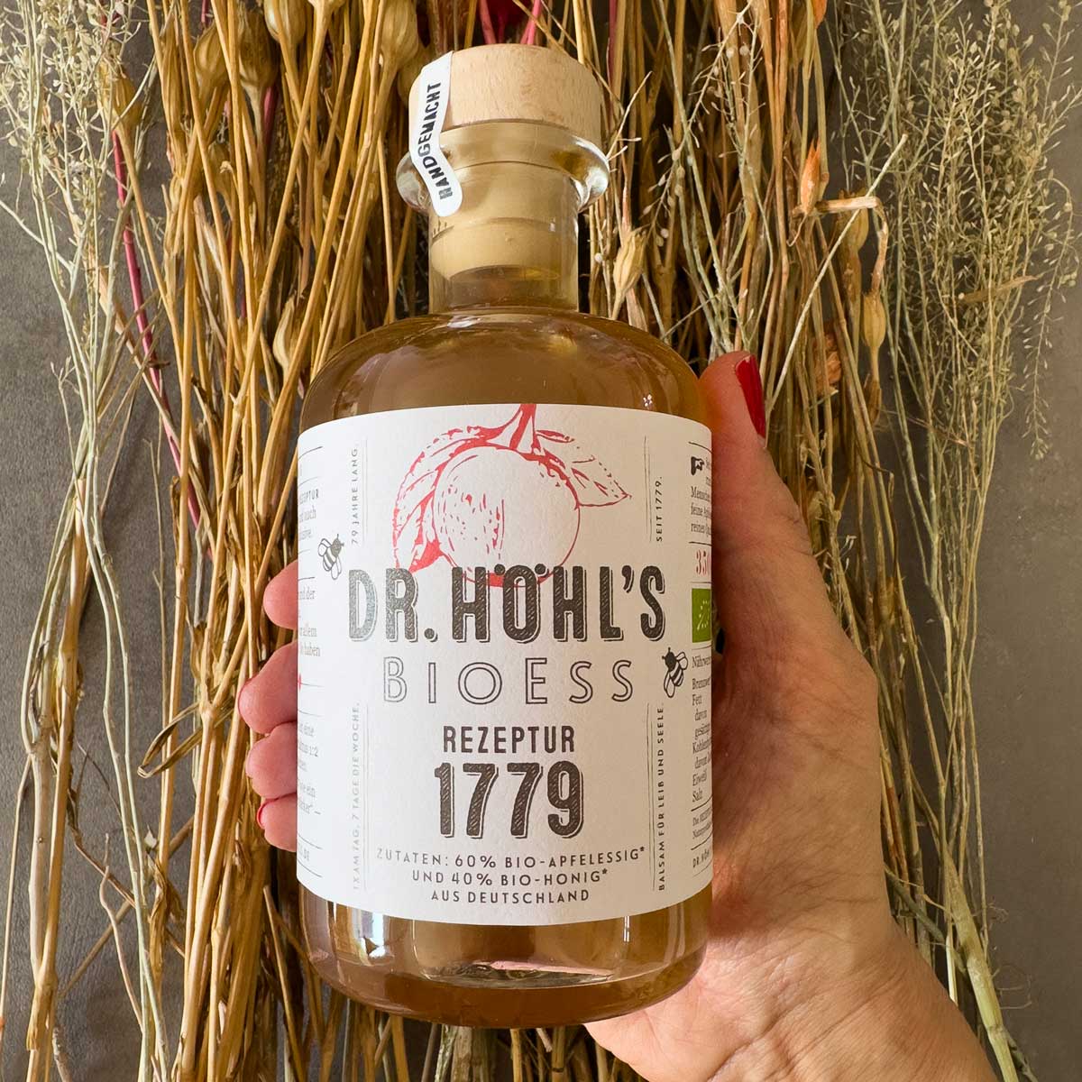 hand hält apotheker flasche apfelessig mit honig rezeptur