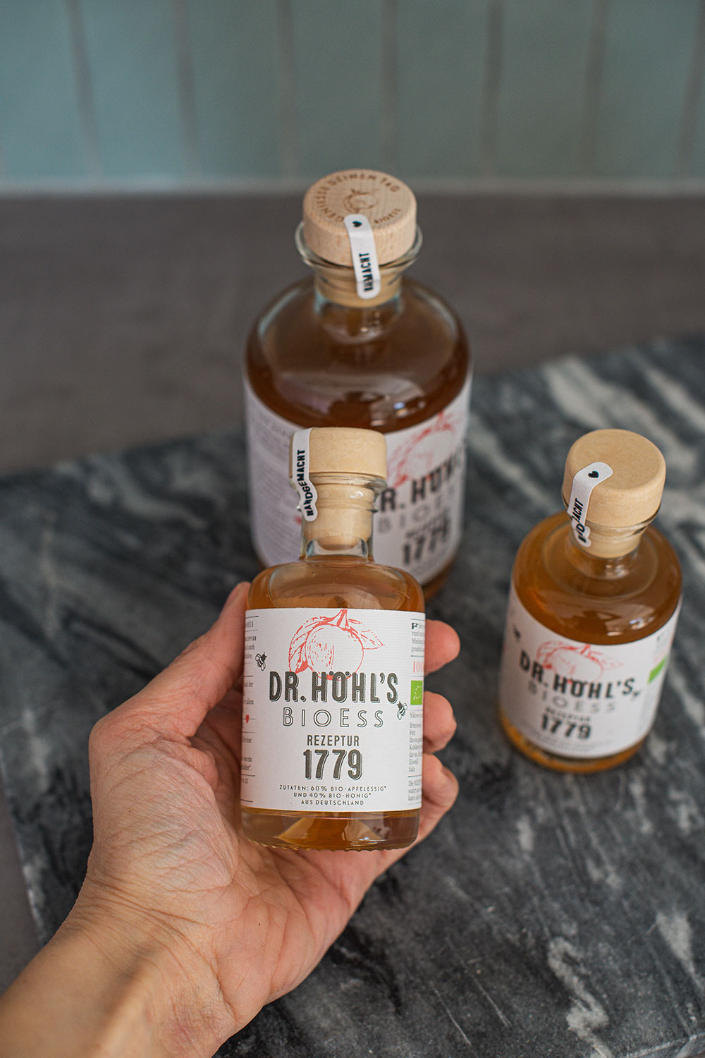 kleine apothekerflasche apfelessig honig mischung in der hand