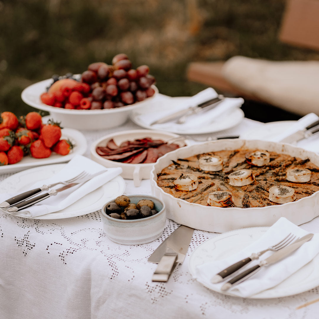 white picknick tisch mit quiche und anderen köstlichkeiten