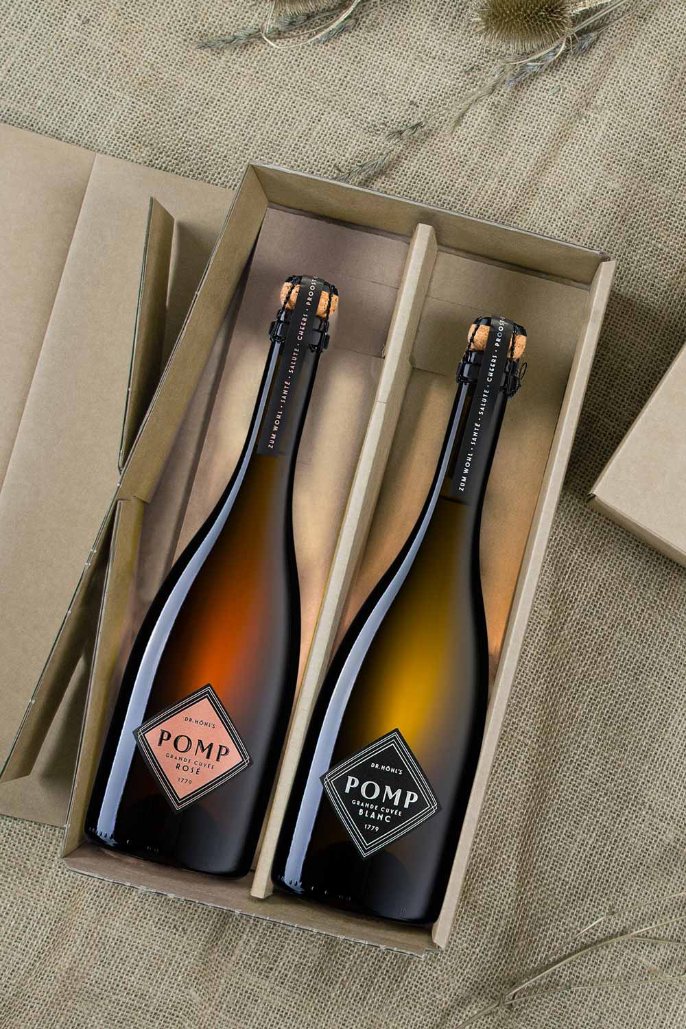 Blick in die Naturkarton Box mit zwei schwarzen Sektflaschen und edlem Design