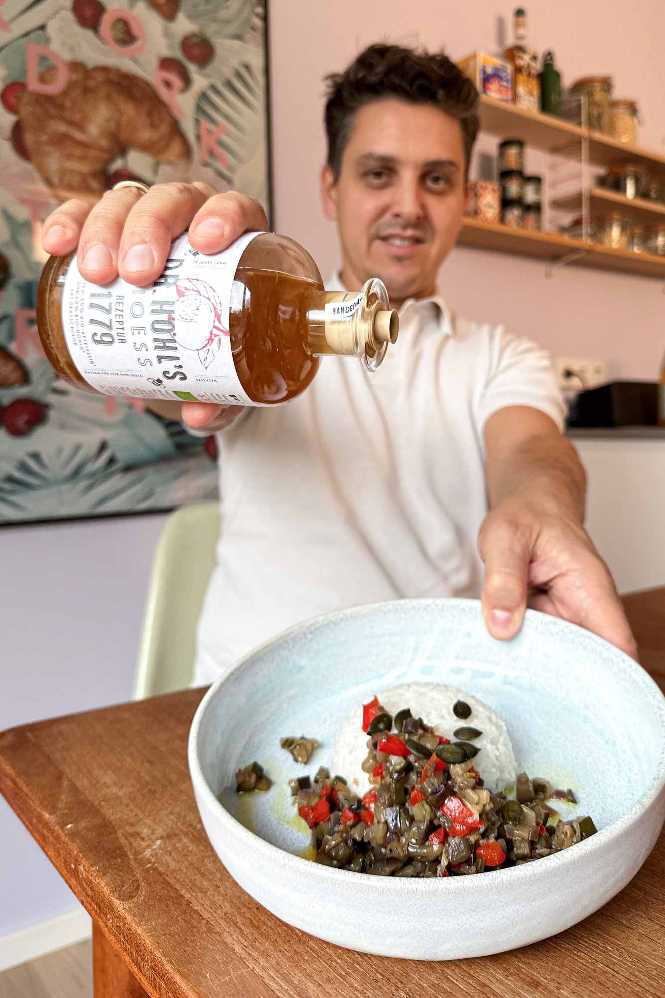 johannes träufelt den natürlichen geschmacksverstärker über das fertige ratatouille mit reis.