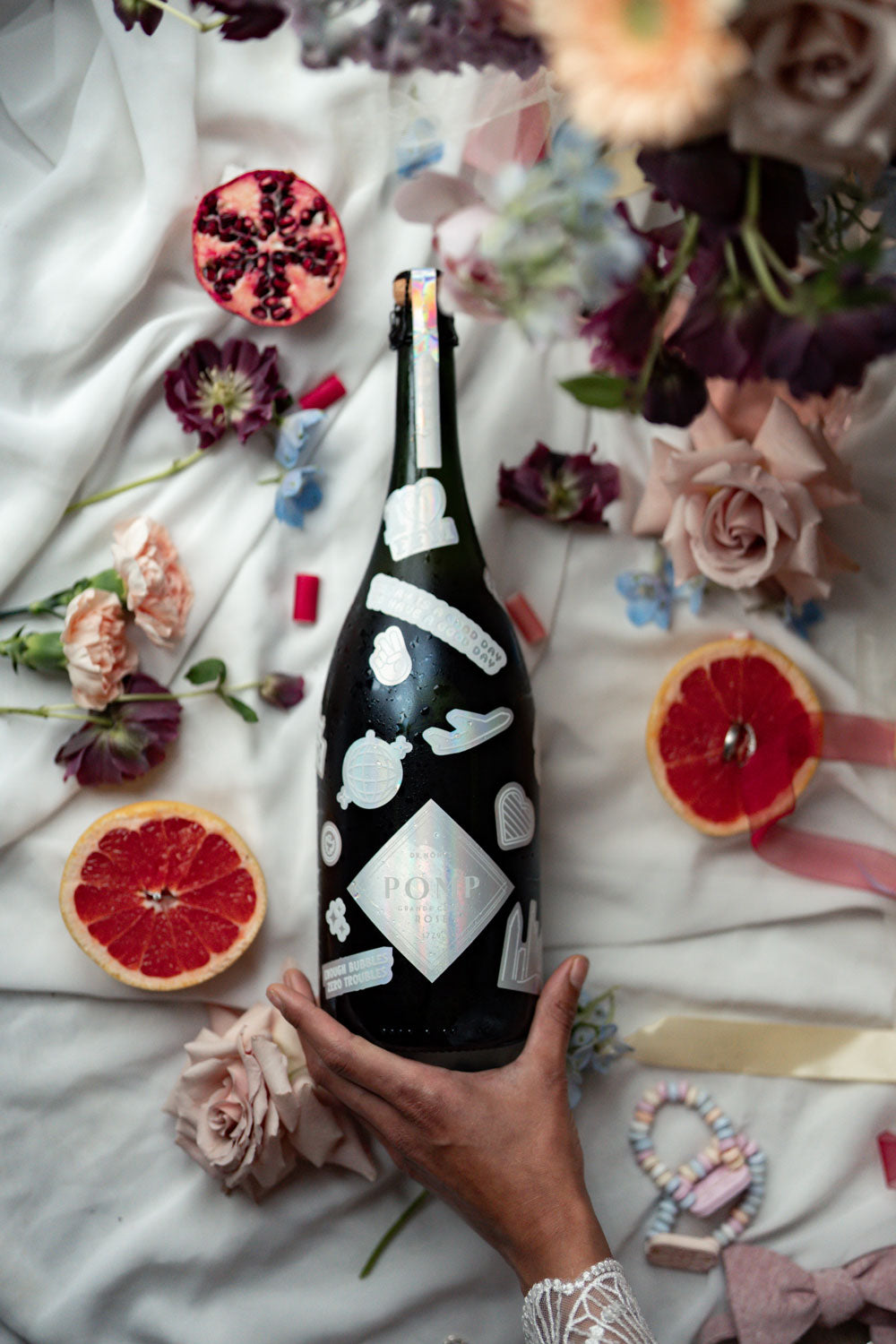 magnum rose sekt flasche mit rainbow stickern in einem hochzeits setting mit blumen