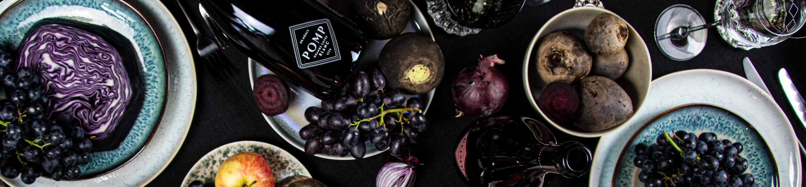 schwarz eingedeckter tisch mit delikatessen und einer schwarzen flasche sekt