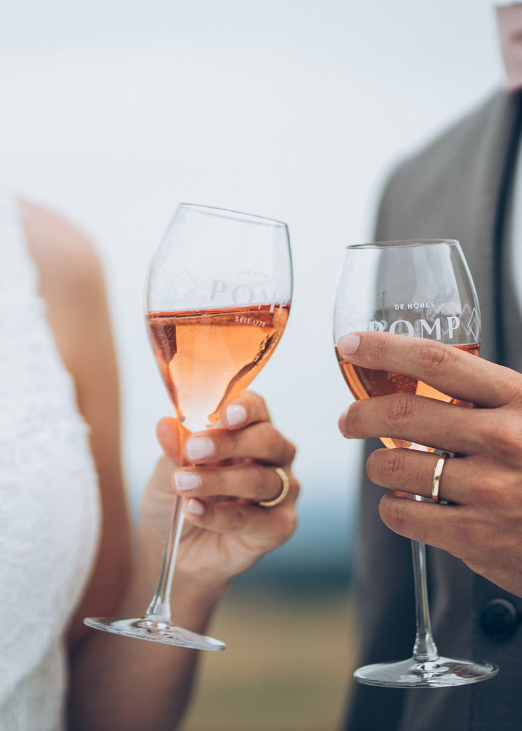 close up brautpaar stößt mit rose sekt an