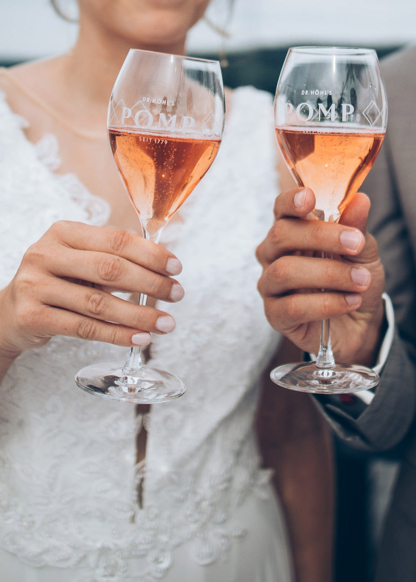 hochzeitspaar stößt mit rose sekt an