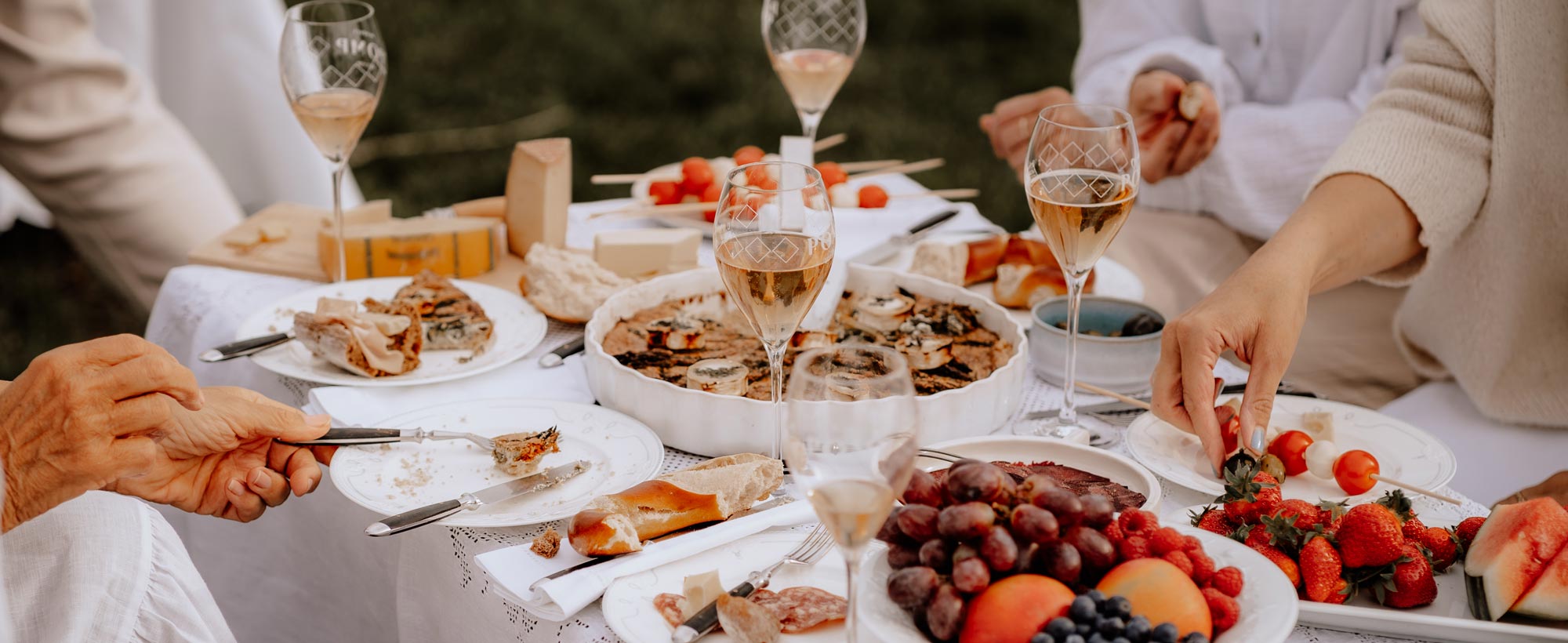 Sommerliches White Picknick mit POMP Sekt, Quiche, Käsebrett, Obst und Brezeln