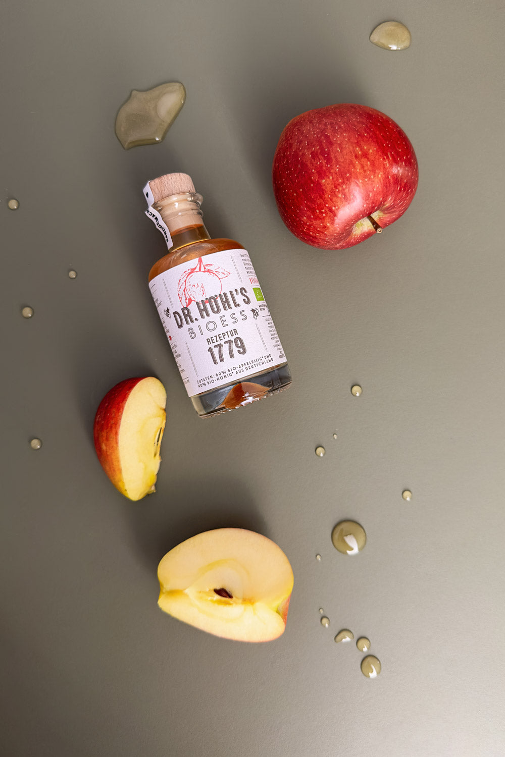 kleine rezeptur flasche zwischen äpfeln und honig klecksen