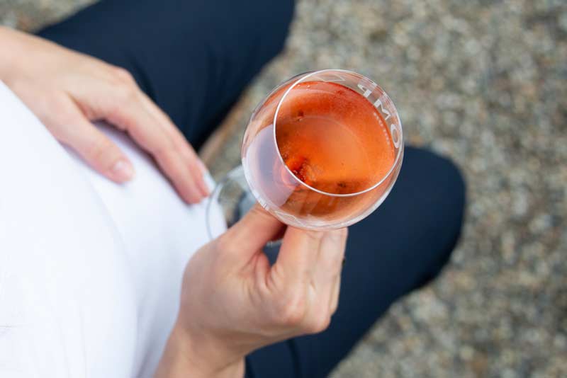 close up schwangere mit einem glas sekt ohne alkohol 