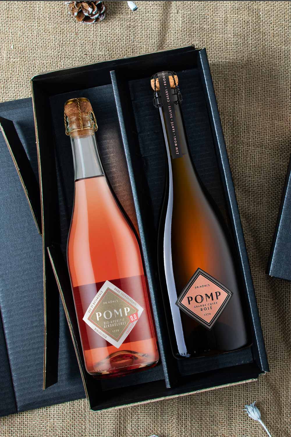 Blick in die schwarze Premium Geschenkbox mit einer flasche bio aperitif alkoholfrei und einer flasche pomp rose sekt