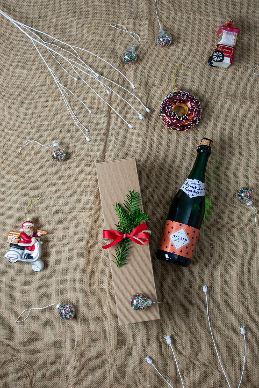 hessische geschenkbox mit einer flasche sekt auf weihnachtlichem hintergrund