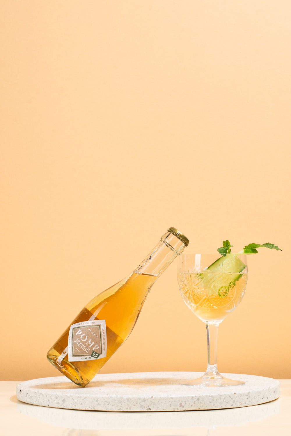 piccolo pomp 00 feinherb alkoholfrei lehr leicht an einem kristallglas mit einer gurkenscheibe