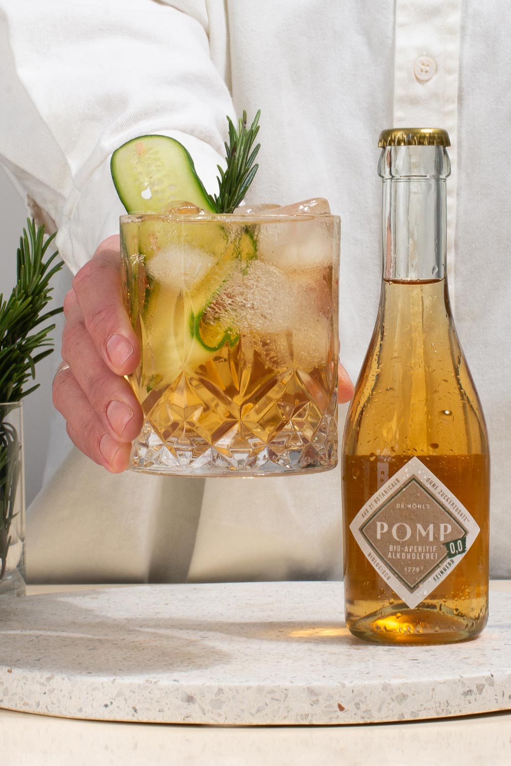 alkoholfreier cocktail im tumbler mit gurkenscheibe und rosmarin mit pomp 00 feinherb