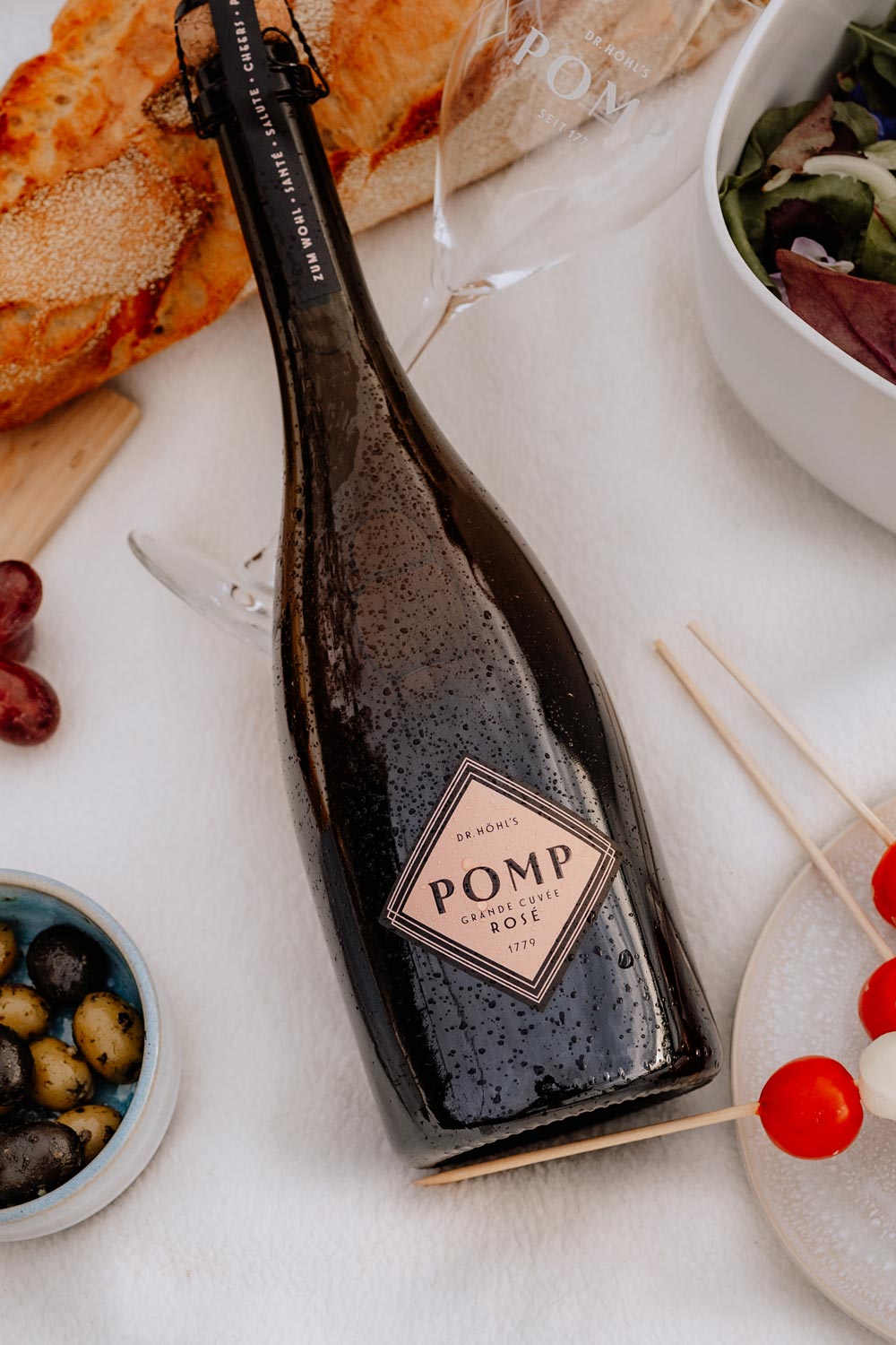 pomp rose flasche auf einer picknick decke liegend