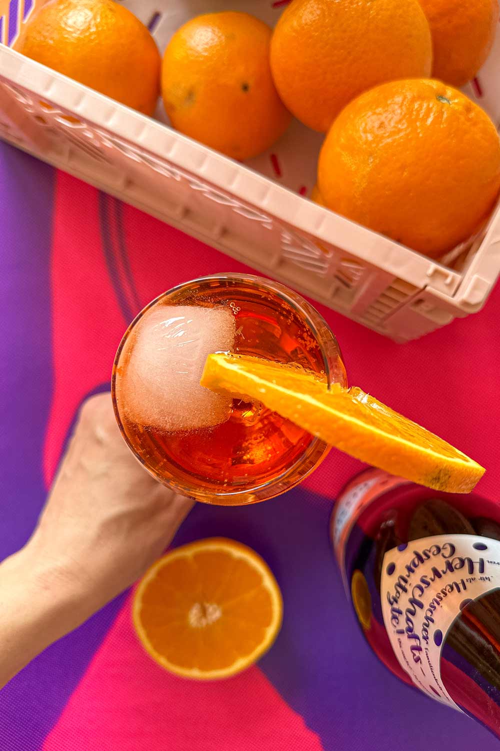 aperol spritz mit orangen auf pinkem hintergrund
