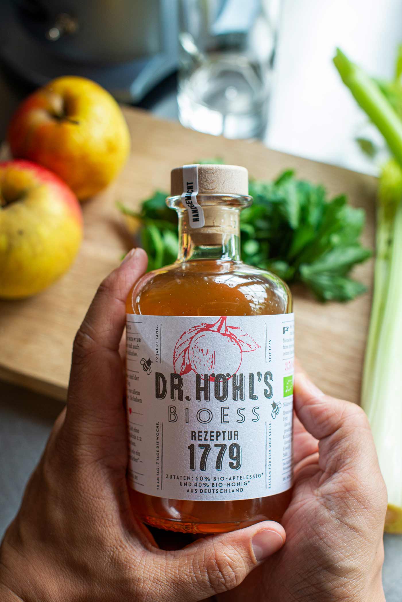 apothekerflasche apfelessig honig mischung wird ehrwürdig von zwei männerhänden gehalten