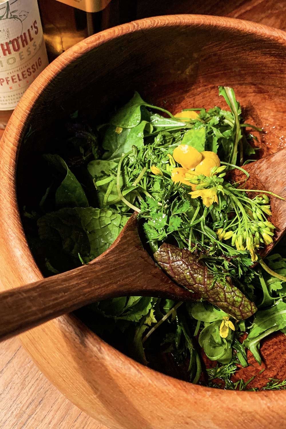 große holzschüssel mit wildkräutersalat mit blüten