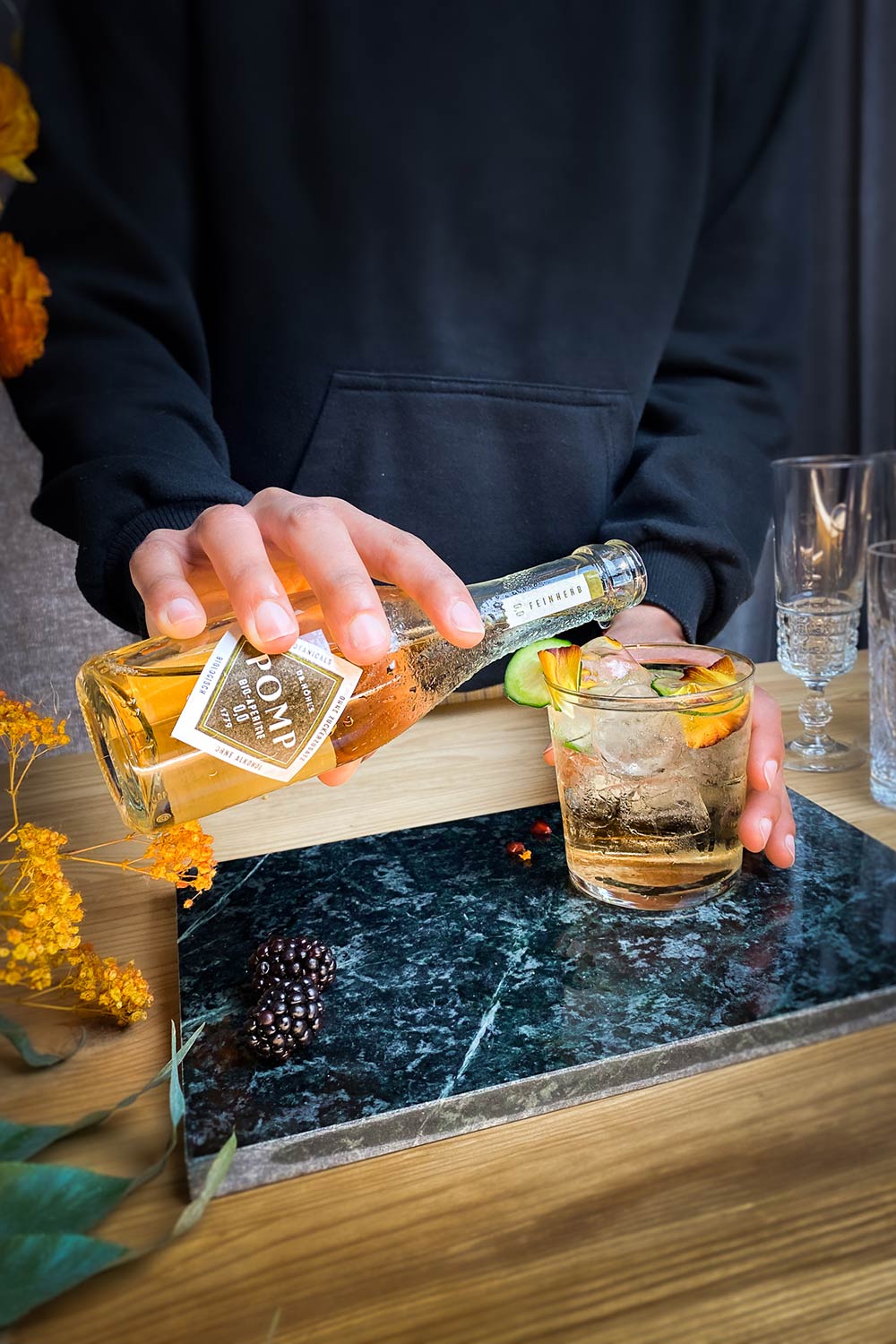 barkeeper füllt bio filler in ein glas mit eiswürfeln