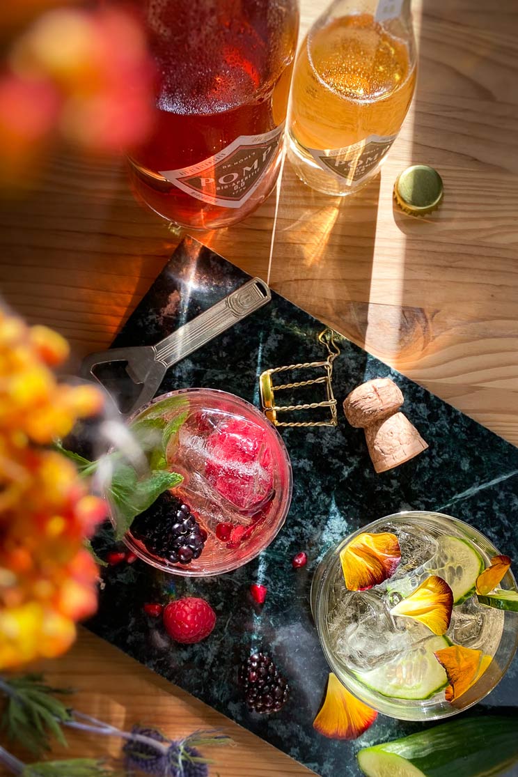zwei alkoholfreie cocktails mit blüten und beeren dekoriert