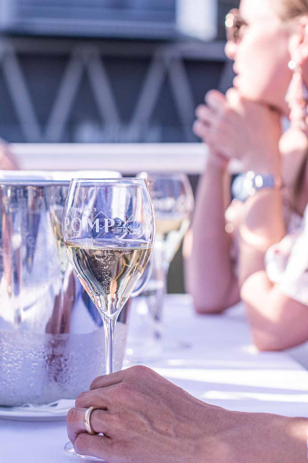 perlage in einem champagnerglas auf weißer tischdecke bei sonnenschein