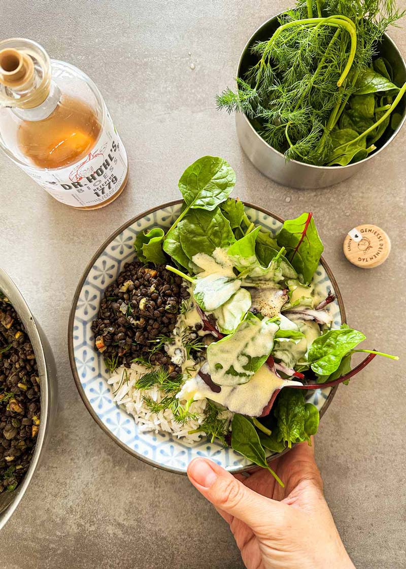 blick in eine bowl mit spinatsalat linsensalat und apfelessig honig dressing