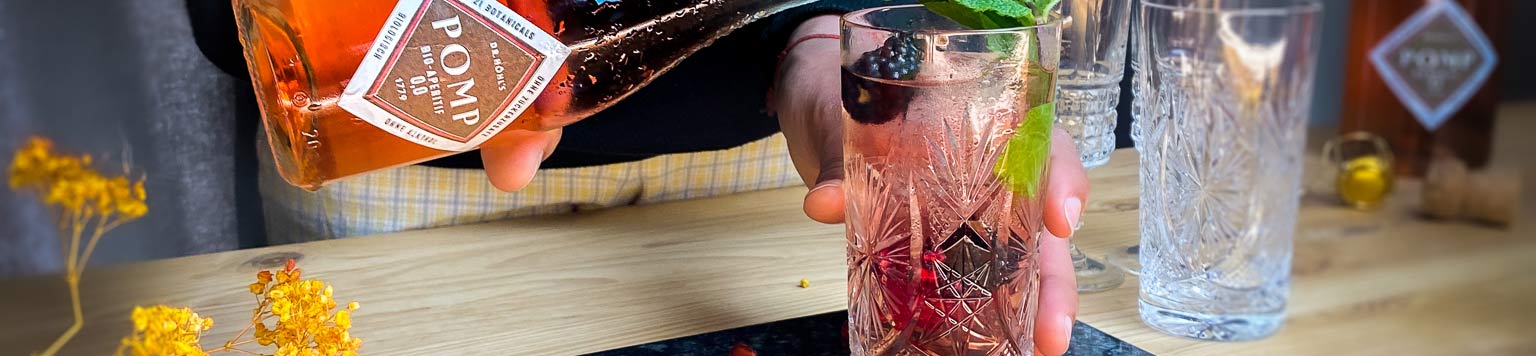 alkoholfreier drink in kristallglas wird mit pomp bio aperitif fruchtig aufgefüllt