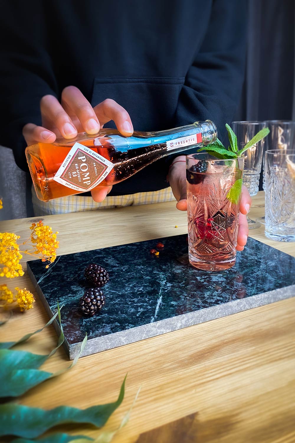 alkoholfreier drink in kristallglas wird mit pomp bio aperitif fruchtig aufgefüllt